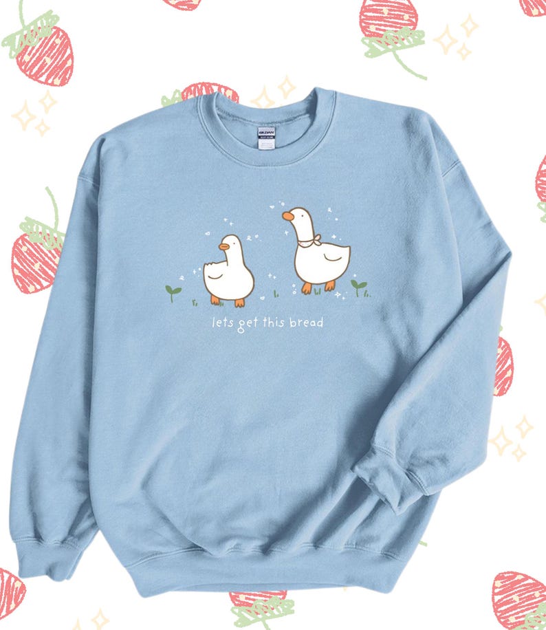 Pastel Blue Whimsical Duck Sweatshirt with a dtg printed design of two ducks surrounded by sparkles, and below it says " lets get this bread"