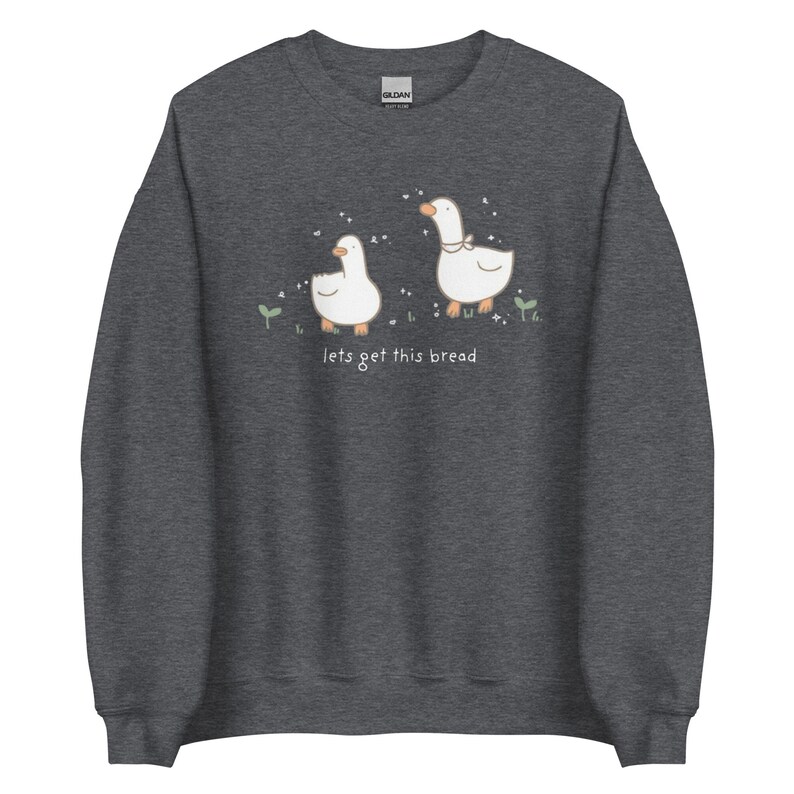 Dark grey Whimsical Duck Sweatshirt with a dtg printed design of two ducks surrounded by sparkles, and below it says " lets get this bread"