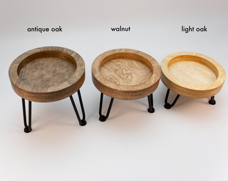 May include: Three wooden trays with black metal legs, each in a different wood stain: antique oak, walnut, and light oak.