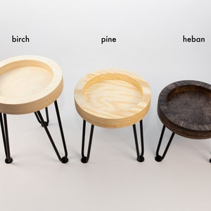 May include: Three wooden plant stands with black metal legs. The stands are made of birch, pine, and heban wood.