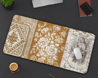 Puede incluir: Una alfombrilla de escritorio rectangular con un diseño de tres paneles. El panel izquierdo tiene patrones florales dorados en relieve, el central muestra ilustraciones florales blancas sobre fondo amarillo mostaza y el derecho un ángel vintage.