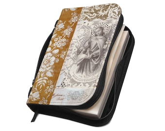 Puede incluir: Una funda para libro con cremallera que presenta un panel amarillo mostaza con un patrón floral blanco junto a un panel central que muestra una ilustración vintage de un ángel con un niño, sobre un fondo de encaje blanco y texto manuscrito.