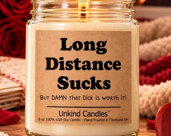 May include: A clear glass jar candle with a lit wick and a tan label featuring the black text Long Distance Sucks, But DAMN that Dick is WORTH it!, Unkind Candles, and 8 oz 100% USA Soy Candle - Hand Poured in Cleveland OH.