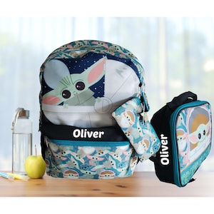 Pode incluir: Um conjunto de mochila, estojo e lancheira azuis com um design Baby Yoda. A mochila tem um gr&aacute;fico Baby Yoda e o nome "Oliver". A lancheira e o estojo tamb&eacute;m apresentam o design Baby Yoda.