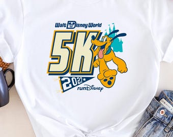 May include: A white short-sleeve t-shirt featuring a graphic of Pluto the dog and the text Walt Disney World 5K 2027 runDisney. The design includes large yellow numbers, a blue castle silhouette, and a blue pennant flag graphic.