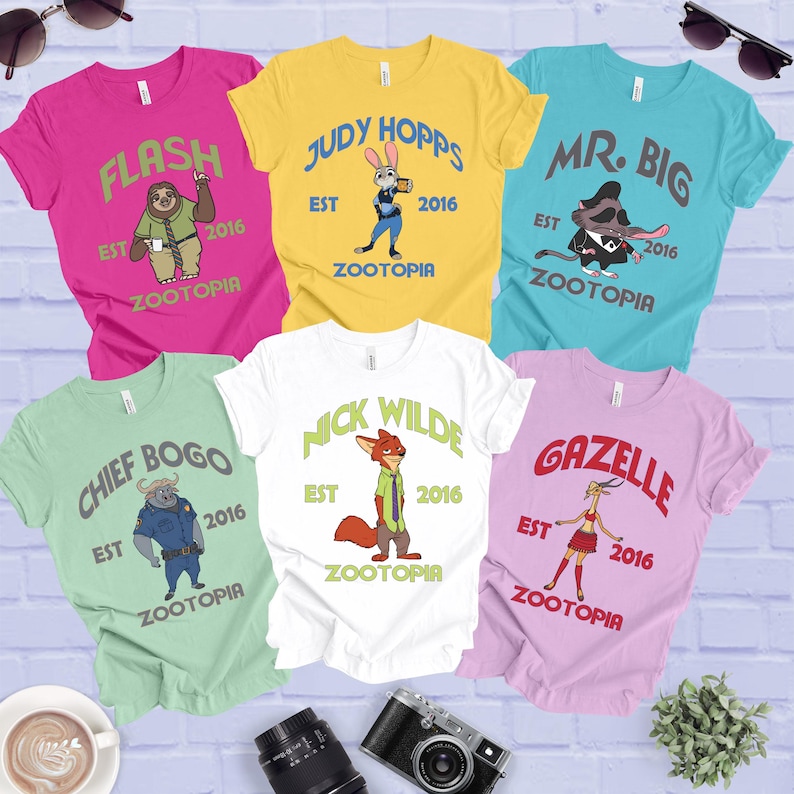 a collection of T-shirts featuring characters from the animated movie "Zootopia", including a sloth, a rabbit, and other animals. The shirts are arranged in a grid-like pattern, with each shirt featuring a different character and the year "2016" printed on it.