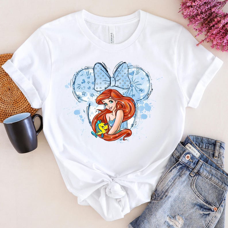 a t - shirt with a picture of a mermaid holding a ball