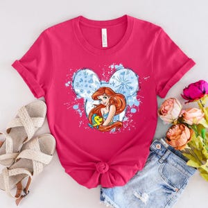 a pink shirt with a picture of a mermaid on it