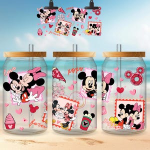 May include: Three clear glass can-shaped tumblers with wooden lids and straws, decorated with Mickey and Minnie Mouse graphics. The designs include pink hearts, ice cream, and the words "love" and "forever". A matching clip holds additional graphics.