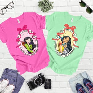 a couple of t - shirts sitting on top of a white brick wall