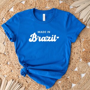 May include: A royal blue t-shirt with white text that reads "Made in Brazil" with a heart symbol.