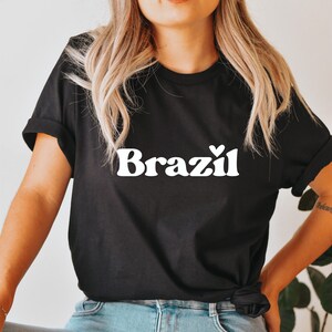 May include: Black t-shirt with white text that says "Brazil" with a small heart above the "l".