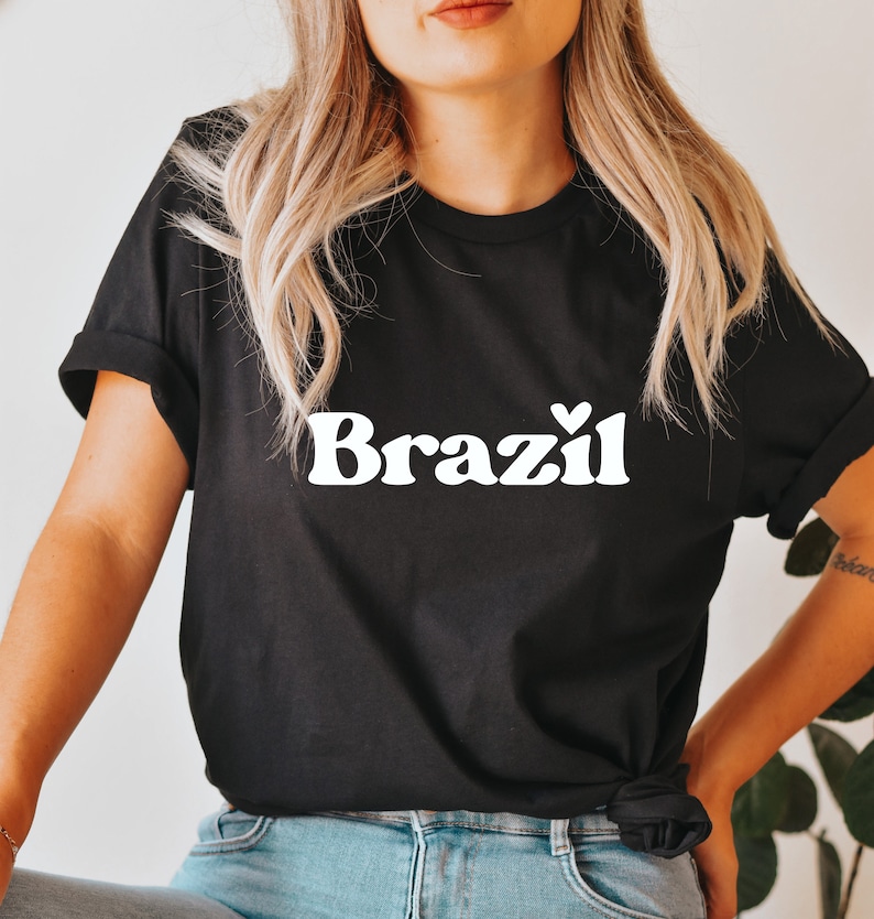 May include: Black t-shirt with white text that says "Brazil" with a small heart above the "l".