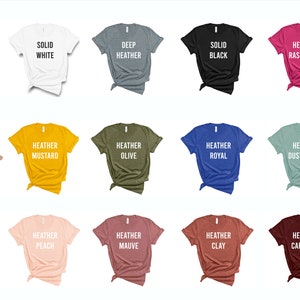 May include: A selection of t-shirt colors, including solid white, deep heather, solid black, heather raspberry, heather mustard, heather olive, heather royal, heather dusty blue, heather peach, heather mauve, heather clay, and heather cardinal.