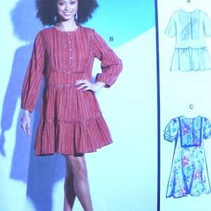 Könnte beinhalten: McCall's Schnittmuster mit einem roten Kleid mit vertikalen Streifen, langen Ärmeln und einem Stufenrock. Das Muster enthält mehrere Ansichtsoptionen mit einfachen Anweisungen. Das Bild zeigt auch Illustrationen anderer Kleid-Designs.