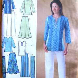 Puede incluir: Un sobre de patrón de costura Simplicity 4149 para tallas 20W-28W. El frente muestra ilustraciones de varios tops, faldas y pantalones, junto a una fotografía de un modelo con una túnica azul estampada y pantalones blancos. El texto incluye Simplicity, easy-to-sew y 4149.