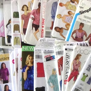 May include: A large collection of assorted sewing pattern envelopes from brands including Simplicity, Butterick, New Look, and McCall's. Each paper envelope features printed illustrations of various clothing designs, model photographs, and specific pattern numbers.