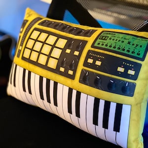 May include: Yellow and black keyboard pillow with a green screen that reads "100 Retro Keys".