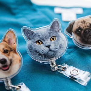 Puede incluir: Tres portatarjetas con tem&aacute;tica de mascotas que presentan un Corgi, un gato gris y un Carlino. Cada carrete tiene una cara de pl&aacute;stico transparente con una imagen detallada de la cara de la mascota. Los carretes tienen un cord&oacute;n retr&aacute;ctil y un clip de pl&aacute;stico transparente.