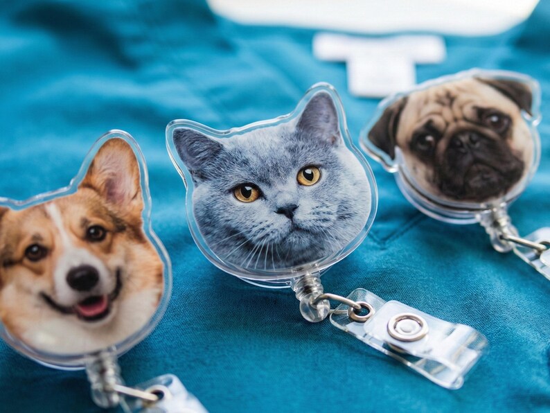 Puede incluir: Tres portatarjetas con tem&aacute;tica de mascotas que presentan un Corgi, un gato gris y un Carlino. Cada carrete tiene una cara de pl&aacute;stico transparente con una imagen detallada de la cara de la mascota. Los carretes tienen un cord&oacute;n retr&aacute;ctil y un clip de pl&aacute;stico transparente.