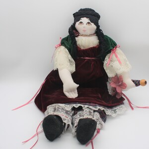 Wunderschöne Vintage Handgemachte Ragdoll trägt ein rotes Samtkleid und hält einen Sonnenschirm
