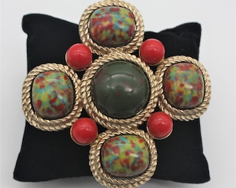 Beautiful vintage gold brooch by Sarah Coventry featuring green and red stones