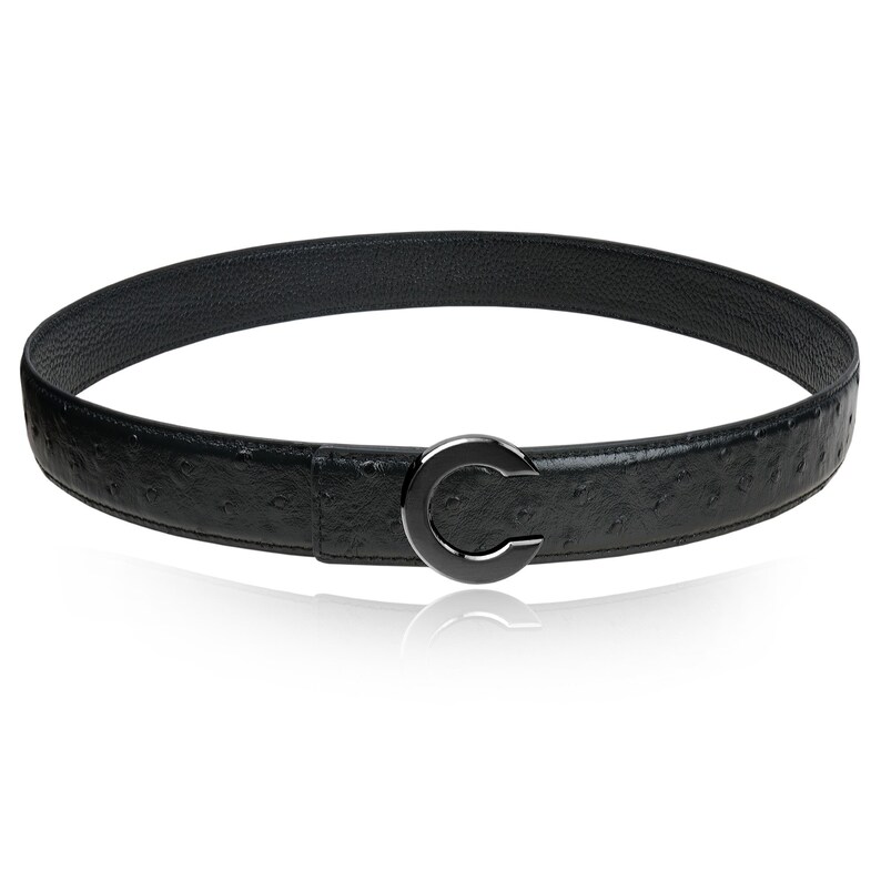 Puede incluir: Un cintur&oacute;n de cuero negro con un patr&oacute;n de piel de avestruz y una hebilla plateada. La hebilla tiene forma de letra C.