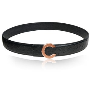 Puede incluir: Un cintur&oacute;n de cuero negro con un patr&oacute;n de piel de avestruz y una hebilla en forma de C de oro rosa.