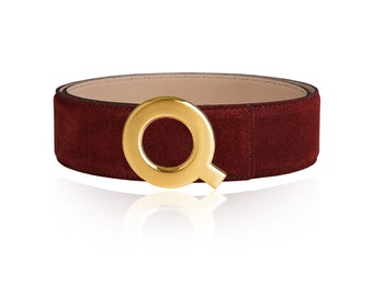 May include: A burgundy suede belt with a gold-toned circular buckle.