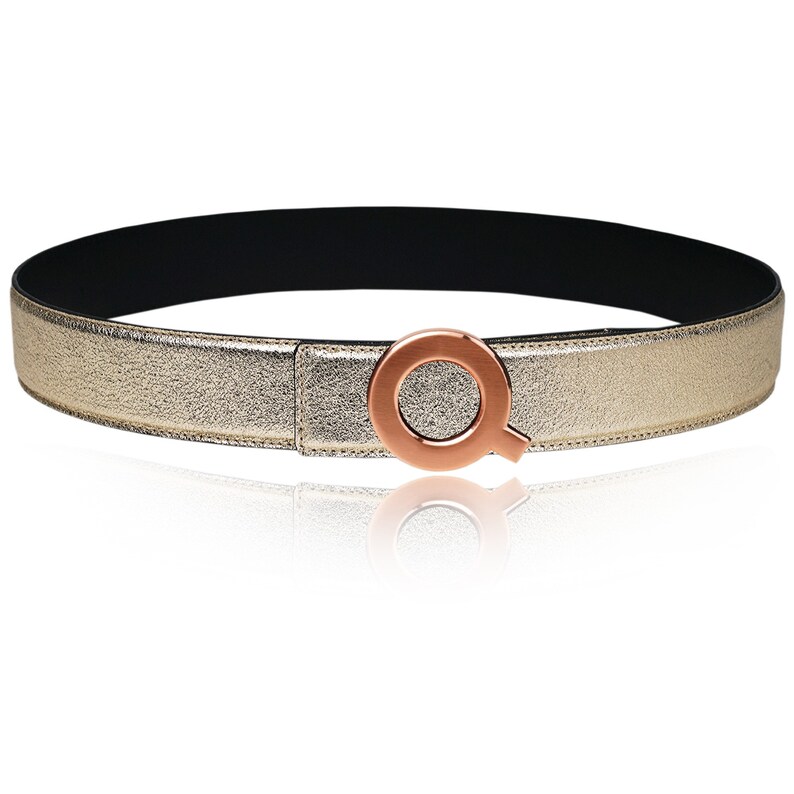 May include: A gold leather belt with a rose gold circular buckle featuring a stylized letter Q.