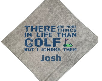 May include: Gray golf towel with the text "There are more things in life than golf but I ignore them Josh".