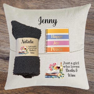 May include: A white pillow with a black fuzzy sock, a colorful notebook with the words "Happy, Joy, Peace" and a book with flowers and wine glasses. The text "Natalie, Just a girl who loves Books & Wine" is on the sock. The text "Jenny" is on the pillow. The text "Just a girl who loves Books & Wine" is on the pillow.