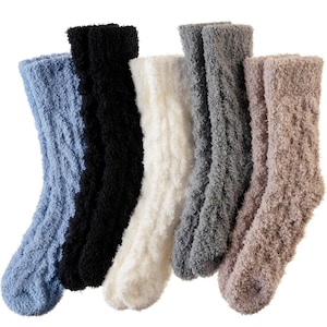 May include: A collection of six fuzzy socks in various colors: light blue, black, white, gray, and tan. The socks have a soft, textured appearance, suggesting a comfortable, warm material. The socks are arranged side by side.