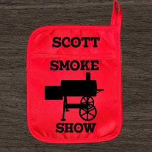 May include: Red cotton pot holder with a black silhouette of a smoker and the text "SCOTT SMOKE SHOW".