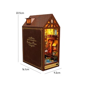 May include: A miniature Colmar Town model, measuring 22.5cm high, 16.1cm wide, and 9.2cm deep. The brown wooden structure resembles a storybook, with a detailed interior visible through the open side. The text "Colmar Town" is displayed on the front.