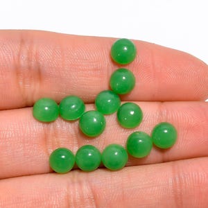 May include: A collection of round, green jade cabochons, perfect for jewelry making or crafting.