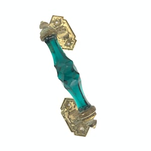 Può includere: Una maniglia per porta vintage in vetro blu turchese con accenti in ottone. La maniglia è sfaccettata e presenta un design decorativo.