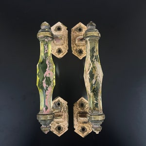May include: A pair of antique door handles with glass knobs. The handles are made of metal and have a white finish. The glass knobs are clear with a green tint and have a diamond pattern.