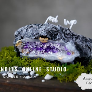 Pu&ograve; includere: Una candela nera e bianca a forma di geode con un interno di cristallo di ametista viola. La candela &egrave; appoggiata su un letto di muschio verde e pietre bianche. Il testo "UNCANDLES ONLINE STUDIO" e "CRYSTAL CANDLE / XIAO AI" &egrave; visibile sotto la candela. Il testo "Ametista Geode" &egrave; visibile in una forma ovale bianca nell'angolo in basso a destra dell'immagine.