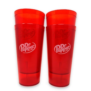 May include: Two tall, translucent red plastic tumblers featuring the white Dr Pepper logo and the text Est. 1885 printed on the front. Each cup has a smooth, cylindrical shape with a slightly wider rim and a flat base, designed for cold beverages.