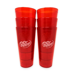 May include: Two stacks of red translucent plastic cups, each featuring the white Dr Pepper logo with the text Est. 1885. The cups have a tapered cylindrical shape with a smooth finish and a visible internal structure at the base of each stack.