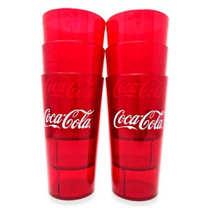 May include: A stack of eight red plastic Coca-Cola glasses. Each glass has the Coca-Cola logo in white. The glasses are transparent and appear to be empty, with a simple, classic design.