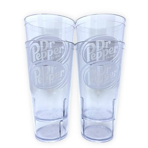 May include: Two clear, textured plastic tumblers featuring the Dr Pepper logo and the text Est. 1885 etched on the front. Each tall, cylindrical cup has a stackable design with a reinforced base and a smooth rim, showcasing a transparent finish.
