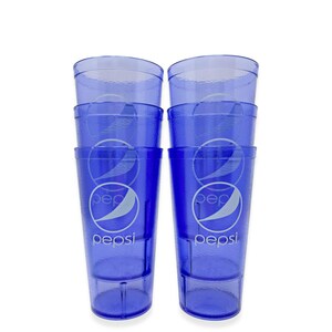 May include: Six blue plastic Pepsi-branded drinking glasses stacked in two columns of three. Each glass has a clear rim and a white Pepsi logo. The glasses are made of a translucent blue plastic.