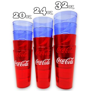 May include: A stack of Coca-Cola branded plastic cups in red and blue. The cups are in three sizes: 20oz, 24oz, and 32oz. The red cups have the Coca-Cola logo in white. The blue cups are clear.