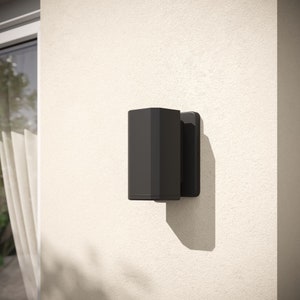 Peut inclure: Un luminaire mural extérieur noir et moderne. Le luminaire a une forme rectangulaire et est monté sur un mur en stuc blanc. Le luminaire projette une ombre sur le mur. Idéal pour l'éclairage extérieur.