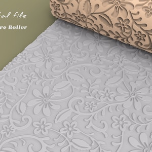 Può includere: Un primo piano di un rullo di texture bianco con un motivo floreale. Il rullo è realizzato in silicone e viene utilizzato per creare motivi in rilievo su fondant, argilla o altri materiali.