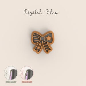 Op de afbeelding: Een strikvormige koekjessnijder met een sterontwerp. De snijder is bruin met een donkergrijze binnenkant en de tekst "Digital Files" in cursief. Twee diagrammen van de rand van de snijder worden onderaan weergegeven.