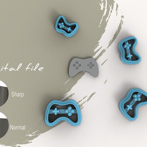 May include: Four blue and gray plastic cookie cutters shaped like video game controllers. The cutters are arranged on a white surface with a gray background. The text "Digital file" is written in black on the background.
