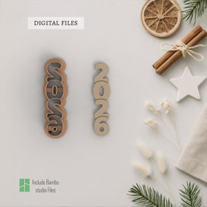 Puede incluir: Dos recortes de números de madera, uno con la palabra "2026" y el otro con los números "2026". Los recortes son de color marrón claro y están sobre una superficie blanca. Las palabras "DIGITAL FILES" e "Include Bambu studio Files" están en la imagen.